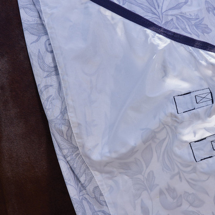 Close-up of a white garment with floral pattern and brand label on a dark surface