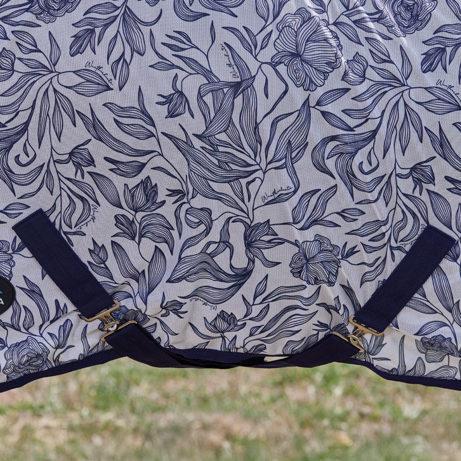 Floral patterned horse blanket with straps on a grassy background