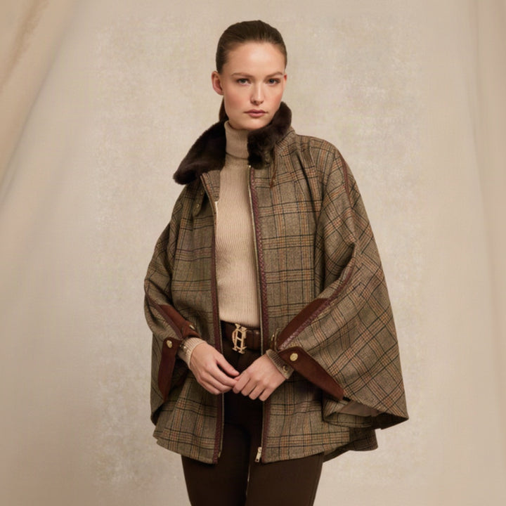Woman wearing a plaid cape with brown trim on a beige background