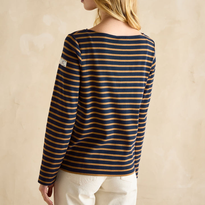 Woman wearing a striped long-sleeve shirt against a beige background