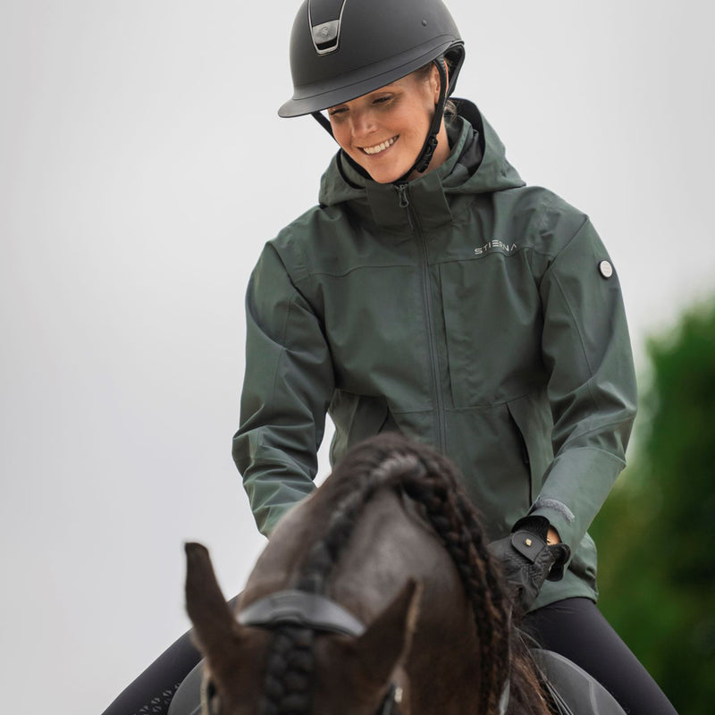 Woman riding a horse wearing Stierna jacket