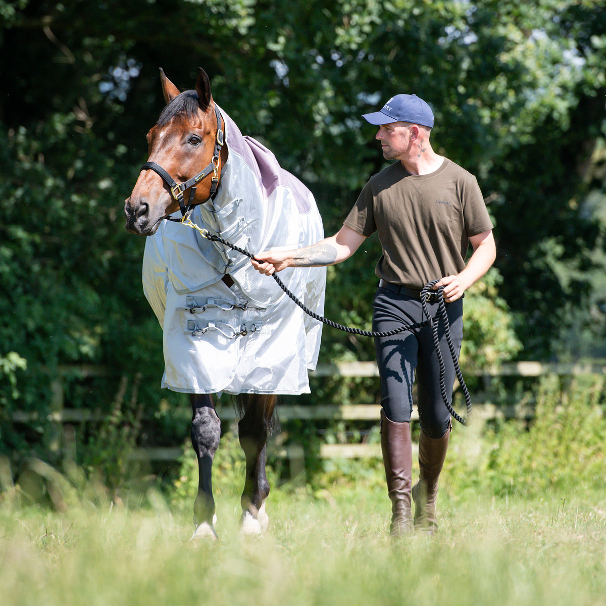 Man leading a horse through a field in a Millbry Hill Elite Stormsafe Rug