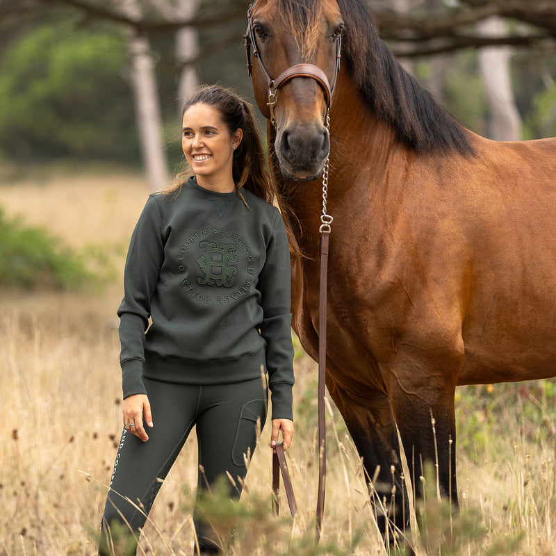 Woman in a field with a horse wearing Holland Cooper clothing