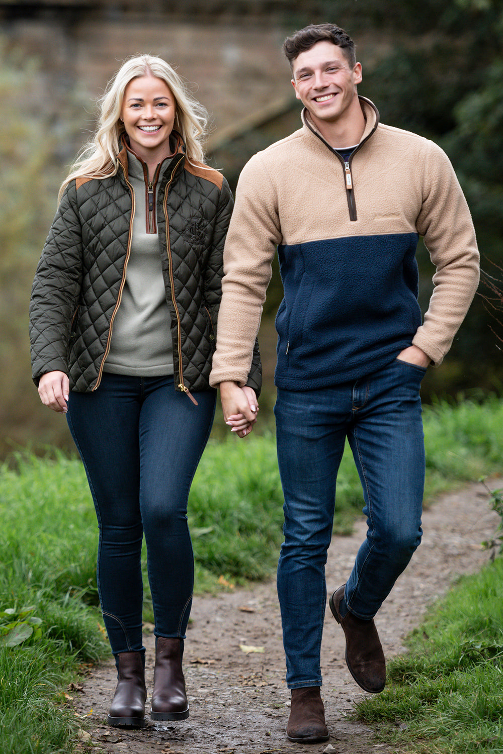 Two people walking hand in hand on a path outdoors