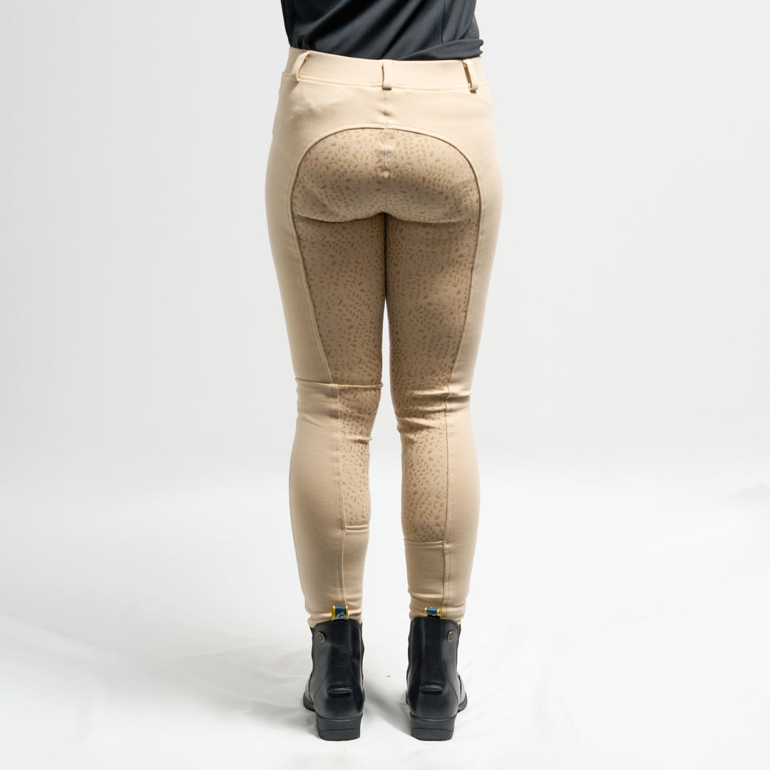 Beige riding tights worn by a person on a white background