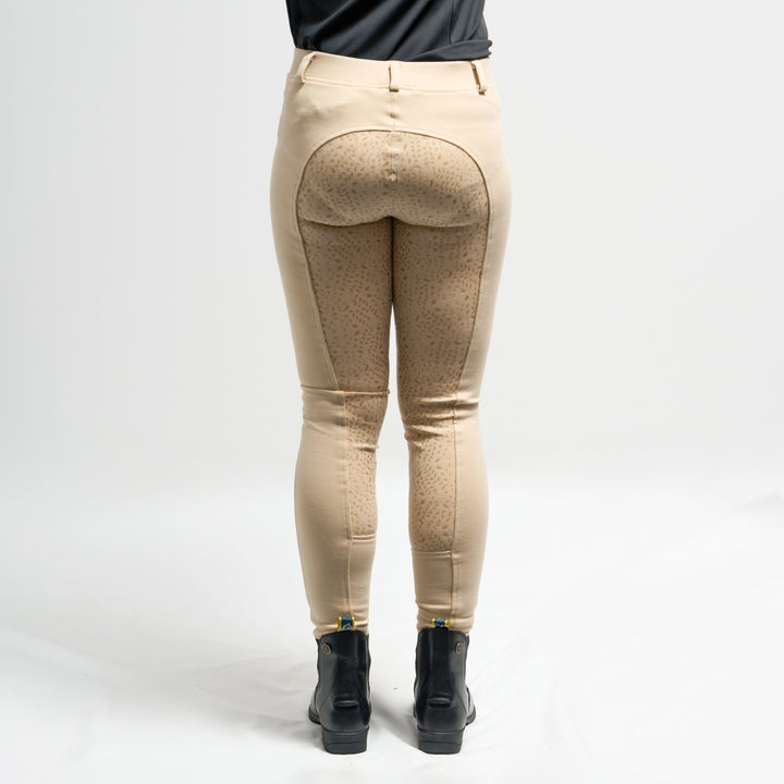 Beige riding tights worn by a person on a white background