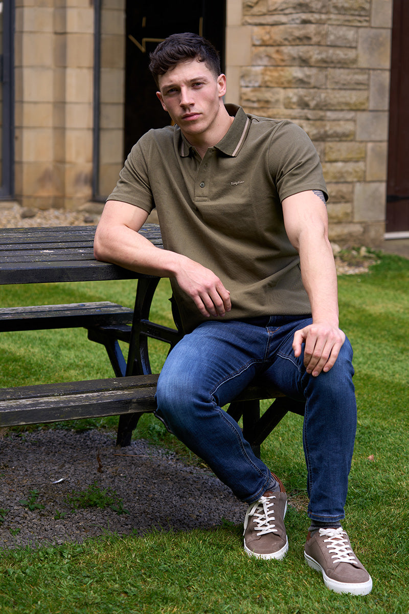 Man sat on a bench wearing Ridgeline & Schoffel clothing