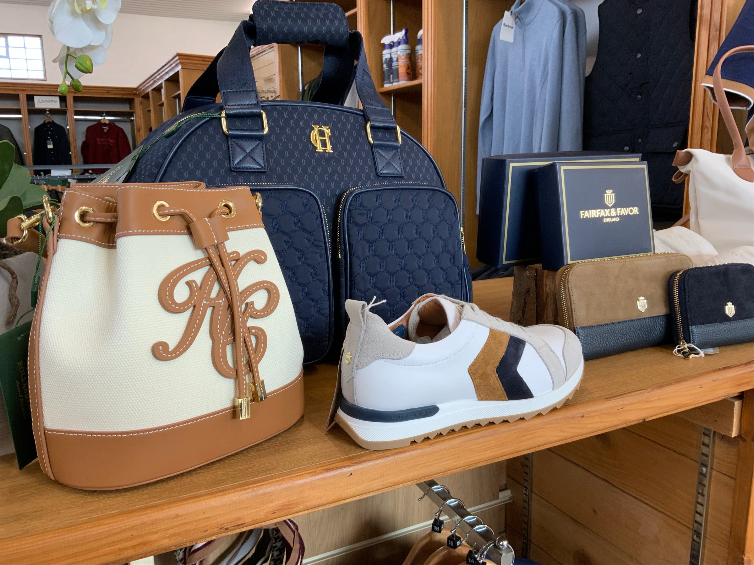 Display of bags and a shoe on a wooden shelf in a store setting.