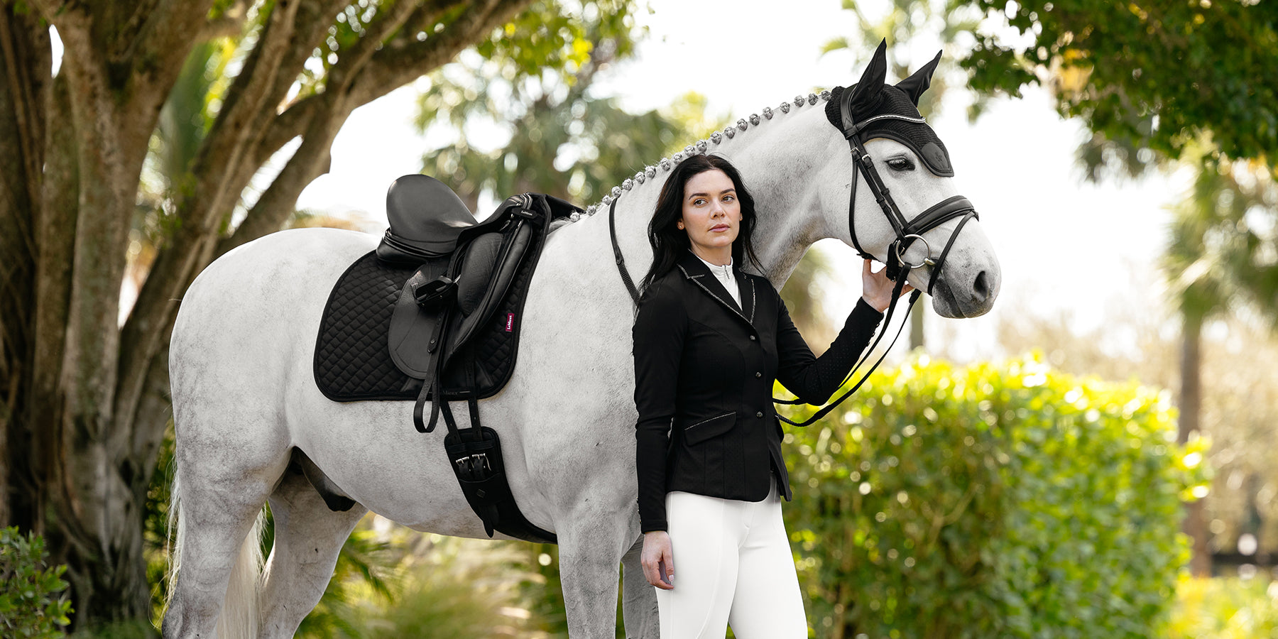 Woman and a horse wearing LeMieux competition clothing