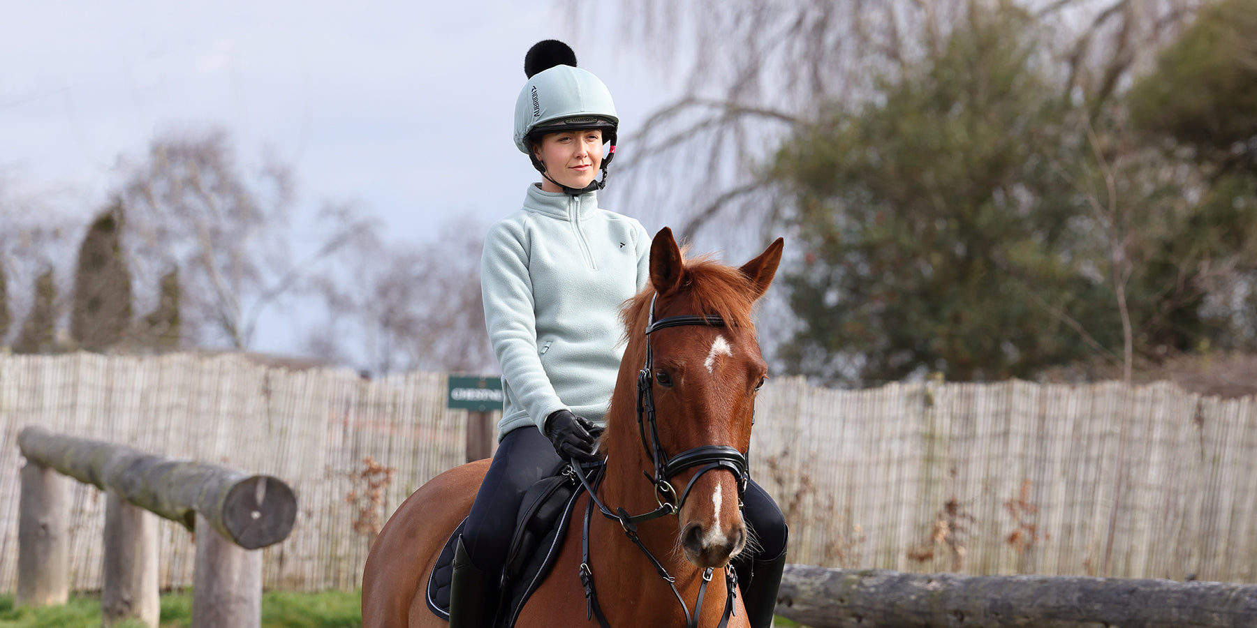 Woman riding a horse wearing Aubrion Sage Clothing