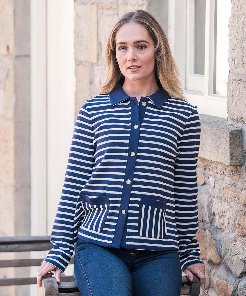 Woman in a striped cardigan sat on a bench